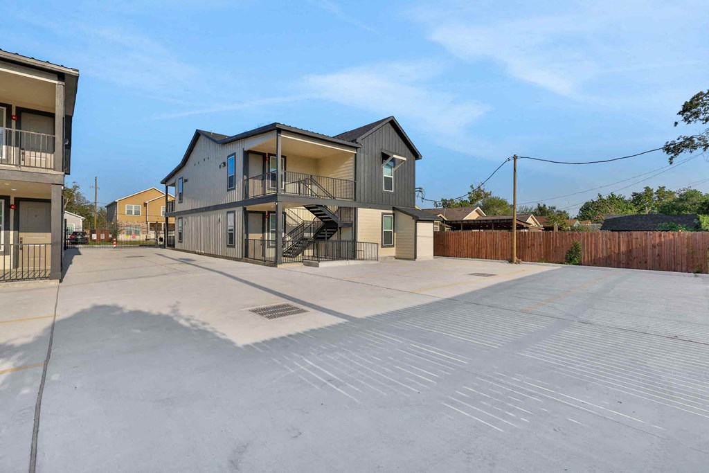 a house with an empty driveway and a building with a staircase