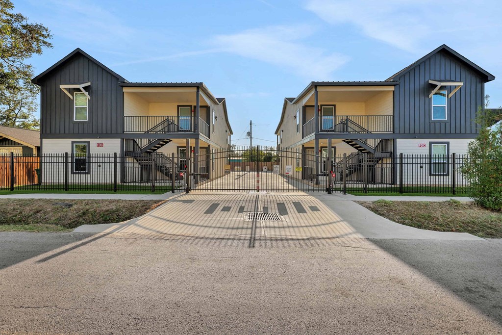 a row of houses with a sidewalk and a gate