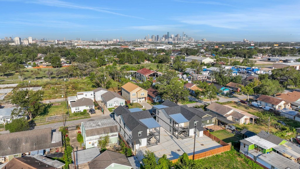 a neighborhood of houses with a city skyline in the background