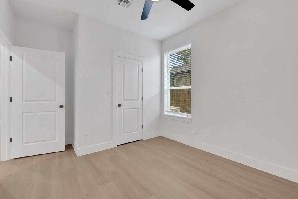 a living room with white walls and a window and a door