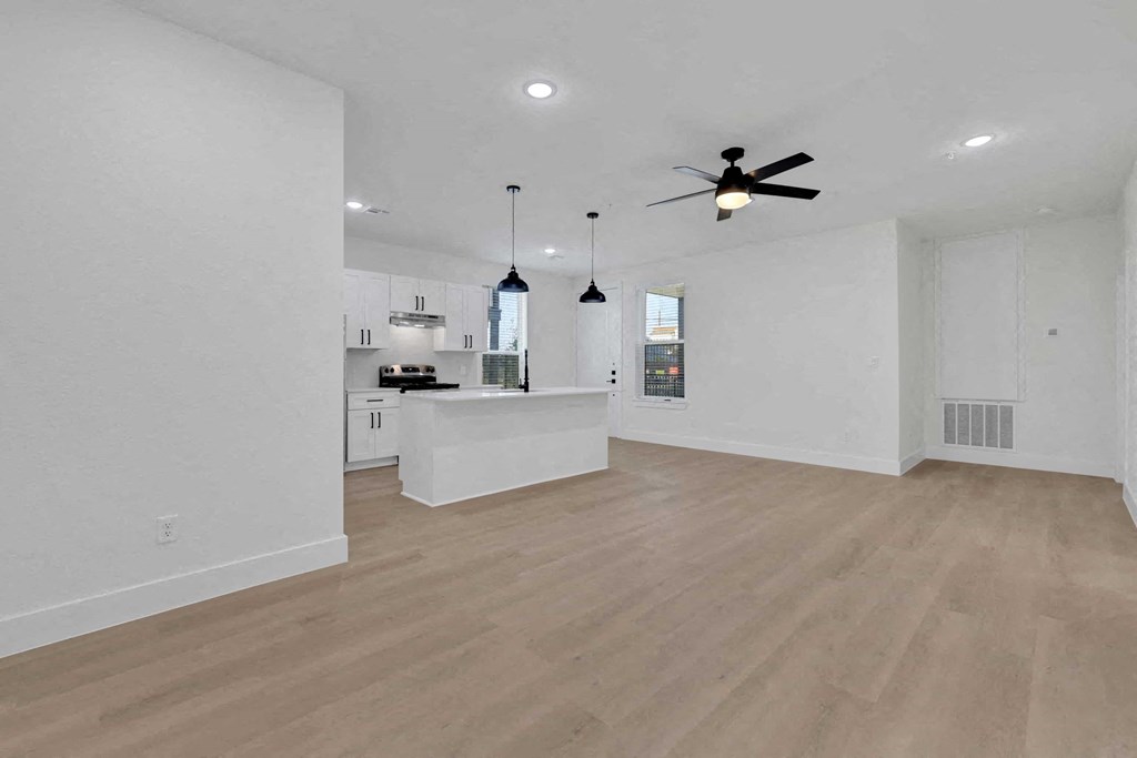 an open kitchen and living room with a ceiling fan