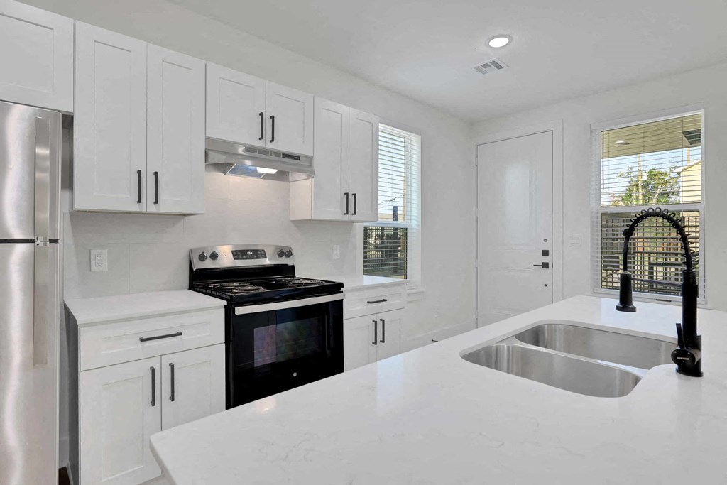 a white kitchen with a sink and a stove