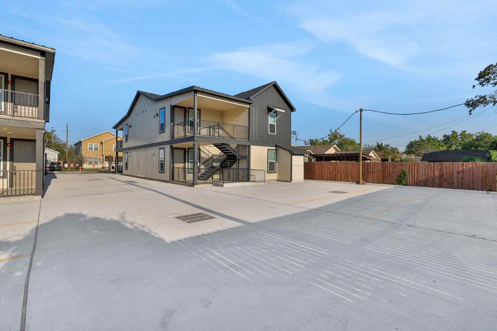 a house with an empty driveway and a building with a staircase