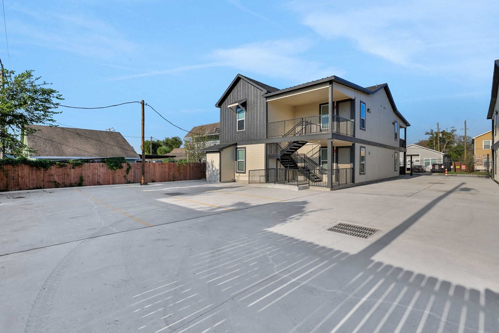 an empty parking lot with a house with a staircase