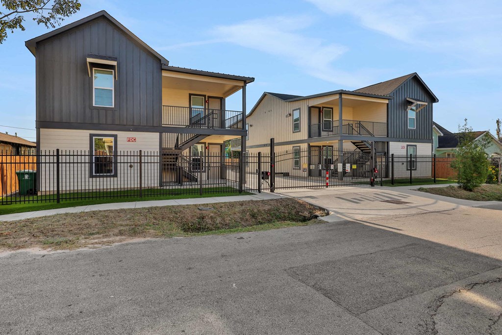a street view of three houses with a fence