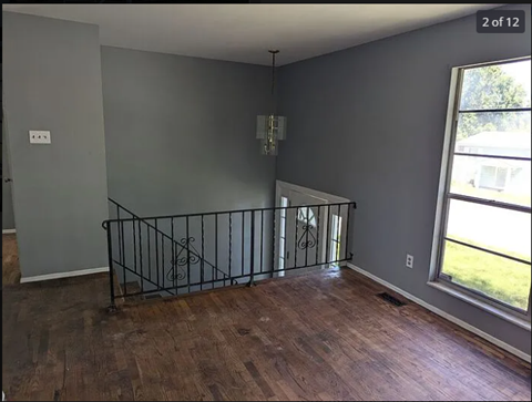 an empty living room with a wood floor and a window