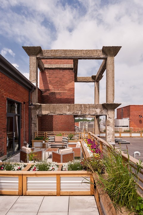 A patio with a table and chairs is surrounded by a brick wall and a wooden fence.