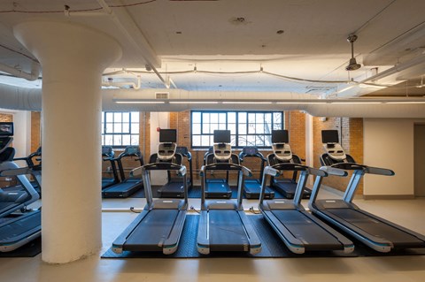 A gym with treadmills and a white column.