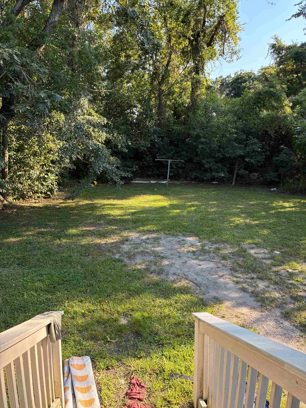 A backyard with a wooden fence and a green lawn.