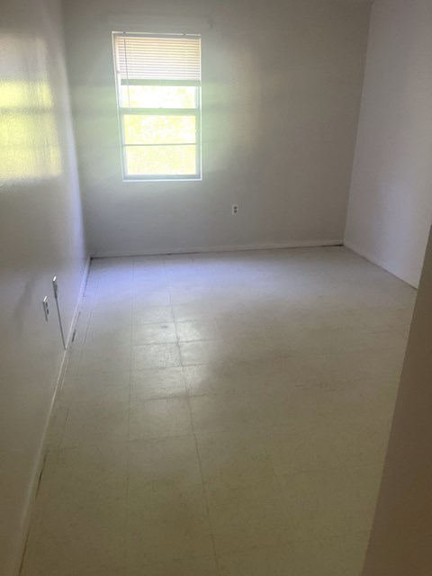 an empty room with white walls and a window