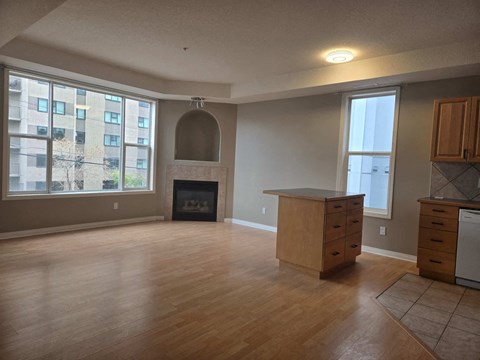 an empty living room with a fireplace and wooden floors