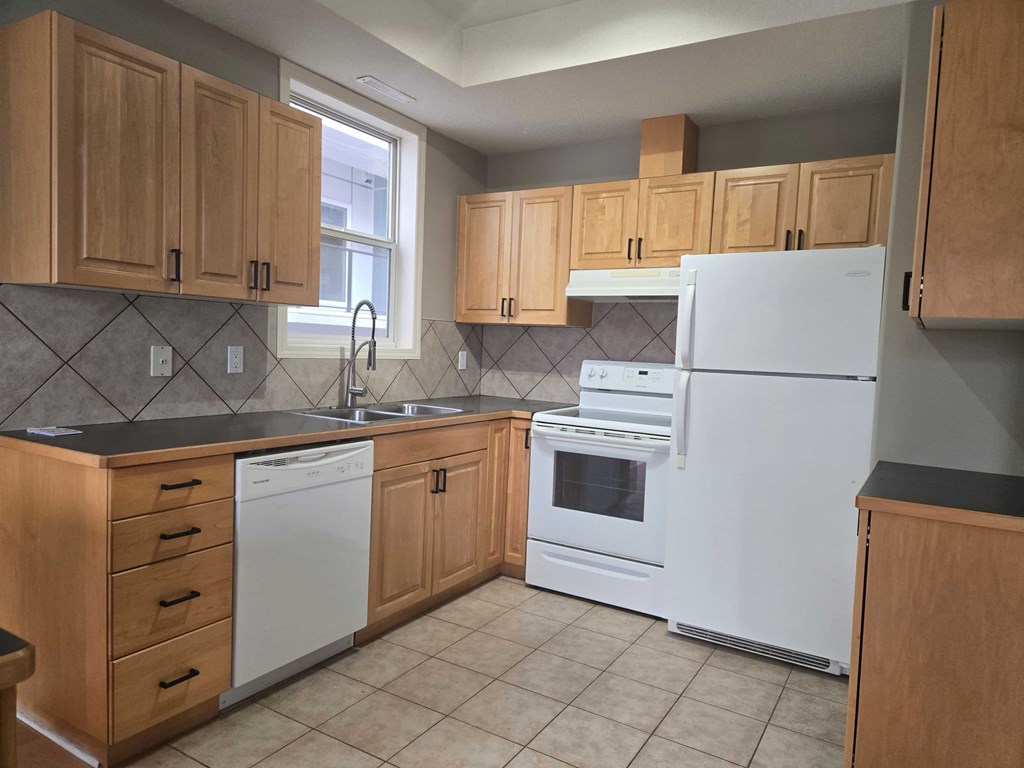 a kitchen with white appliances and wooden cabinets
