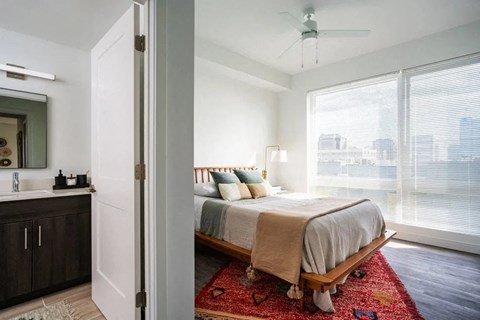 a bedroom with a bed and a large window