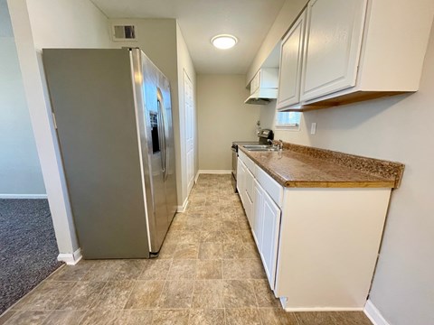 A kitchen with a refrigerator and a counter.