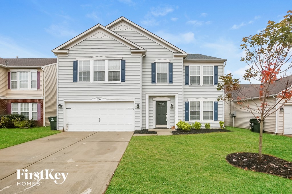 A house with a grey roof and a white garage door.