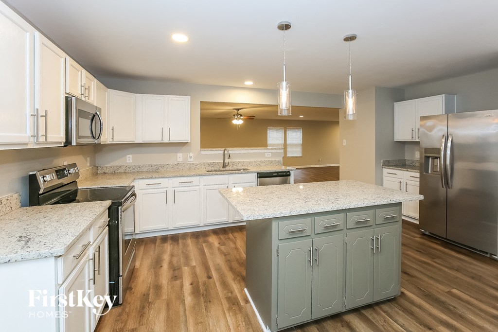A kitchen with wooden floors and a large island.
