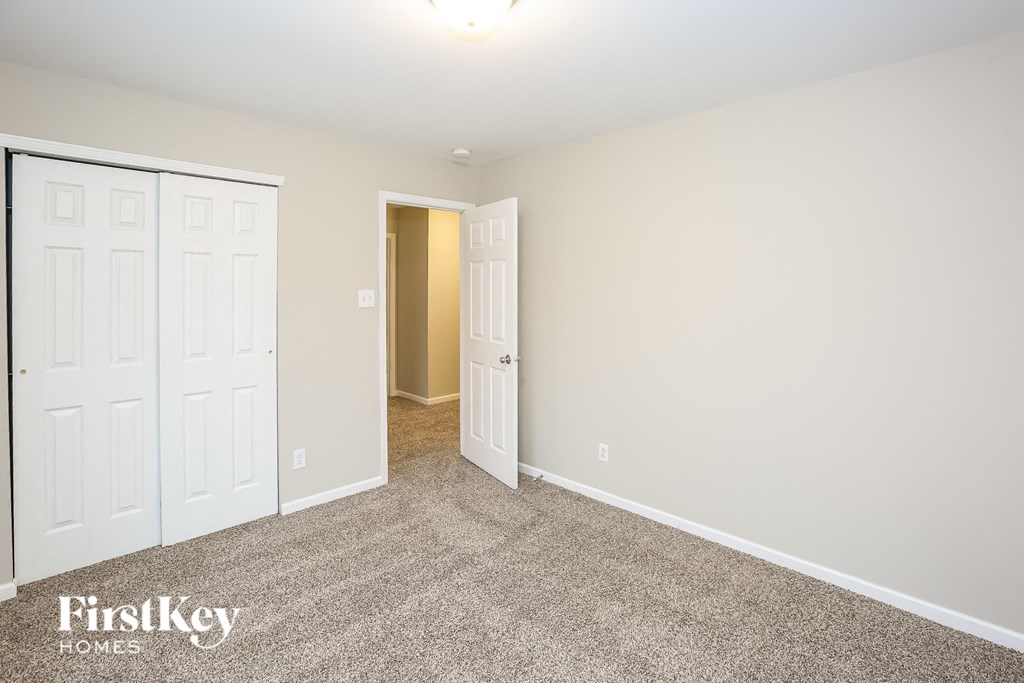 A room with a carpeted floor and a white door.