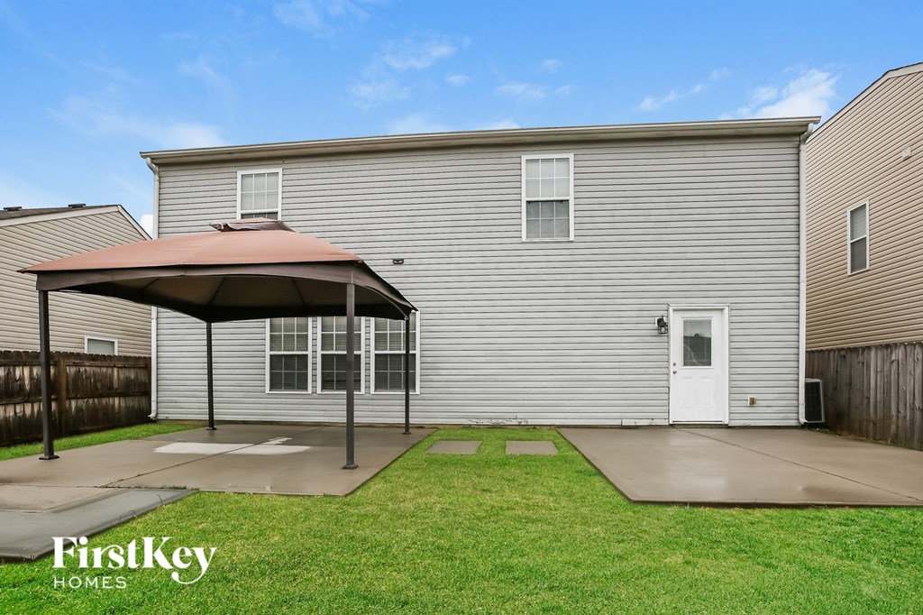 A house with a patio and a covered grill area.