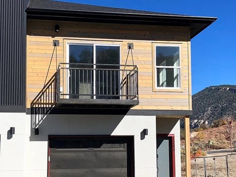 a house with a balcony and a mountain in the background
