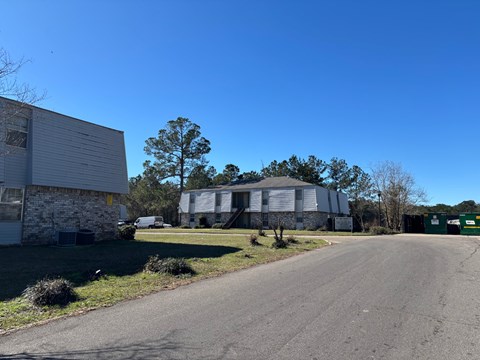 A clear blue sky meets a residential area with houses and trees.