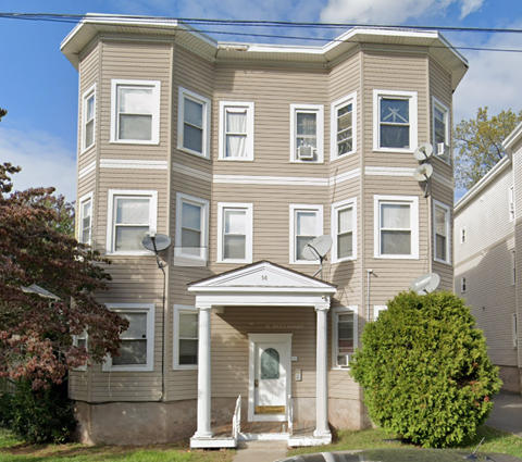 A beige two-story house with a white front door and steps.