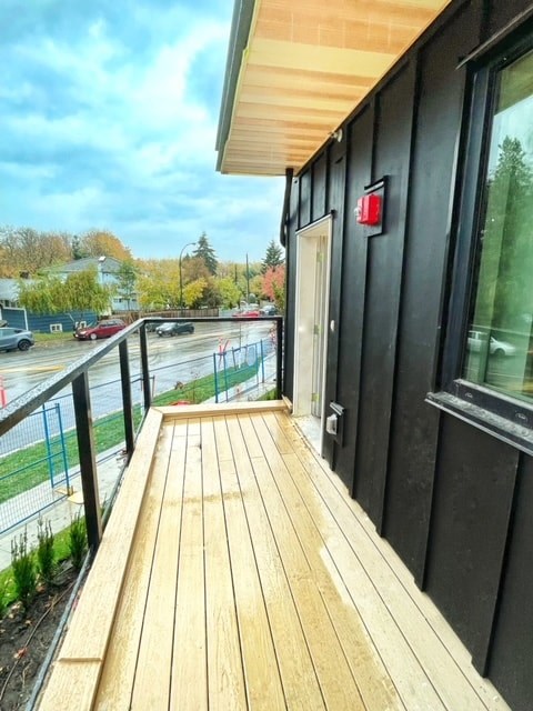 a balcony with a wooden floor and a black building