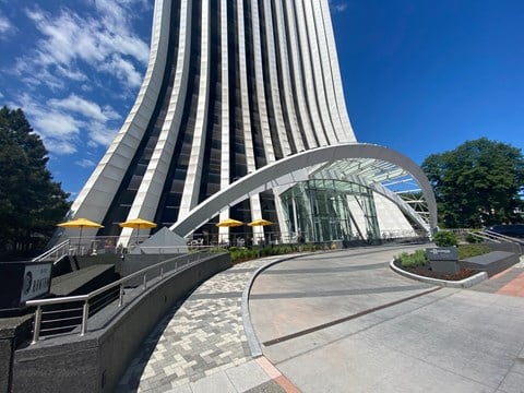A modern building with a curved glass entrance and a metal staircase.