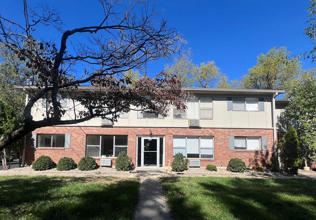 a large brick building with a tree in front of it