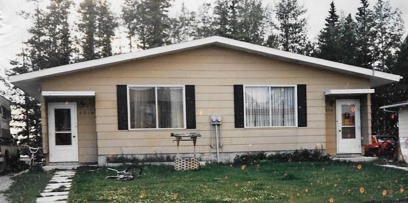 A small house with a white door and a window with a white curtain.