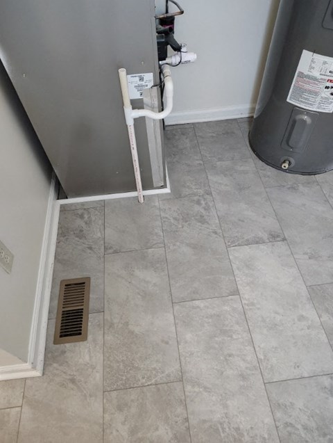 a tiled floor in a room with a furnace and a heater