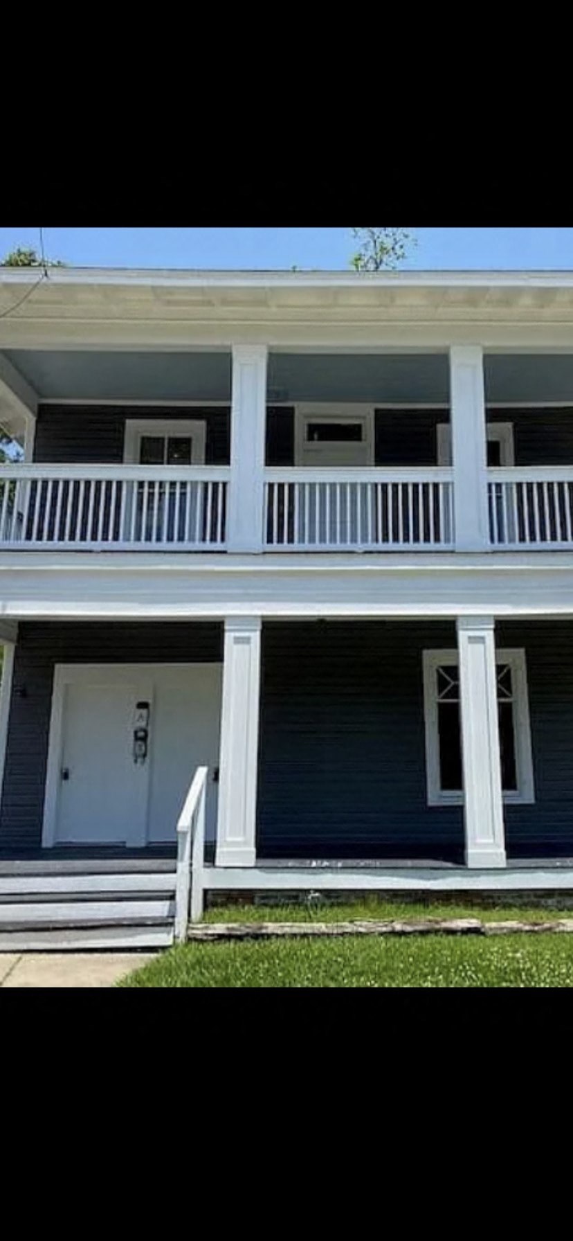 A blue house with white trim and a white door.