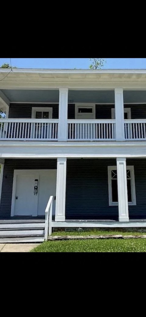 A blue house with white trim and a white door.