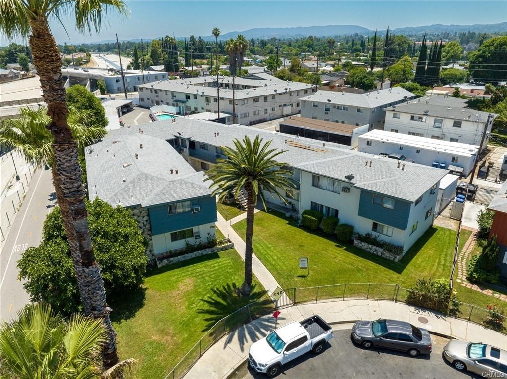 A view of a residential area with houses and parked cars.