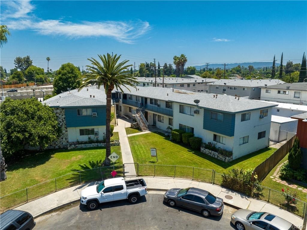 A palm tree stands in front of apartment buildings.