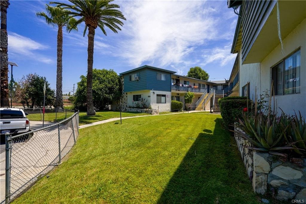 A sunny day in a residential area with houses and palm trees.