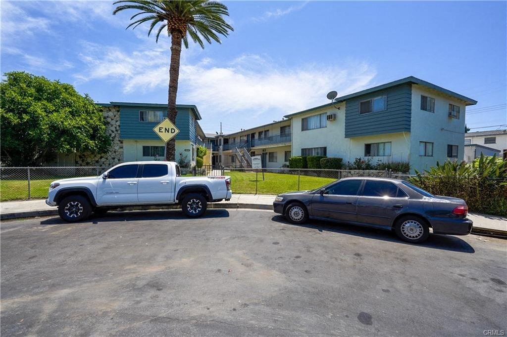 A white truck and a black car are parked in a lot.