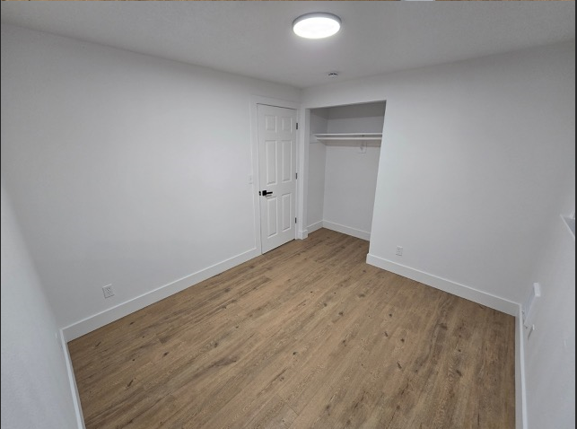 A room with wooden flooring and a white door.