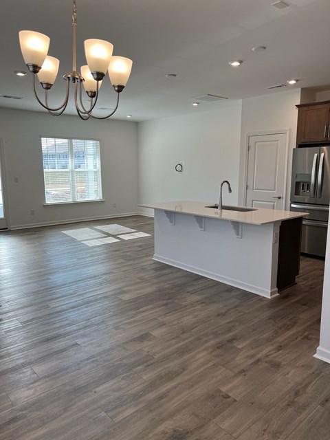 A kitchen with a white counter and wooden floors.