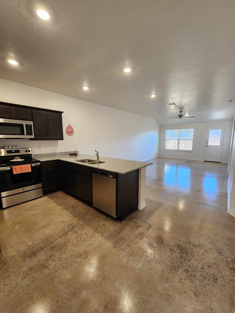 A kitchen with a stove, oven, and microwave.