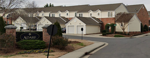 a street of houses in a suburban neighbourhood with a adare sign