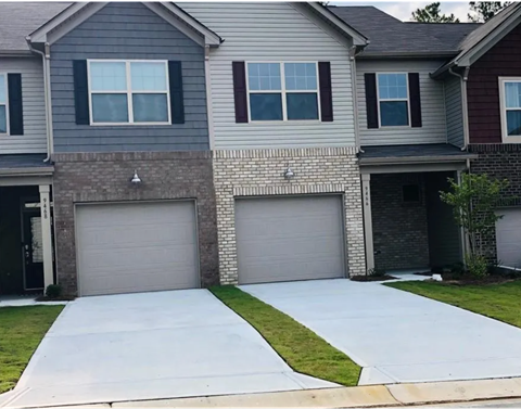a white driveway in front of a house with two garage doors