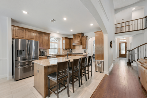 a kitchen with stainless steel appliances and a large island with chairs