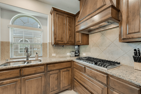 a kitchen with wooden cabinets and a stove and sink