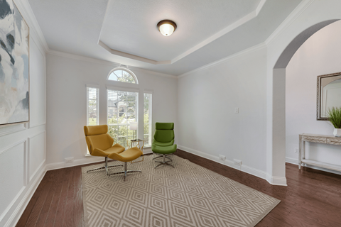 an empty living room with two chairs and a rug
