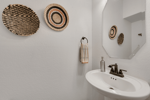 a bathroom with a sink and three baskets on the wall