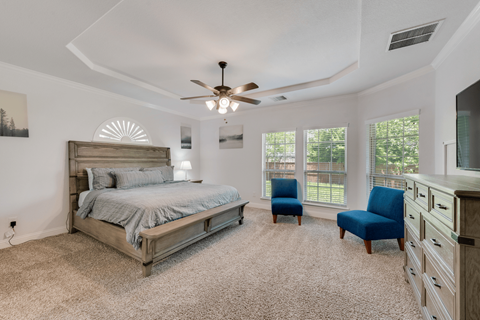 a bedroom with a bed and a ceiling fan