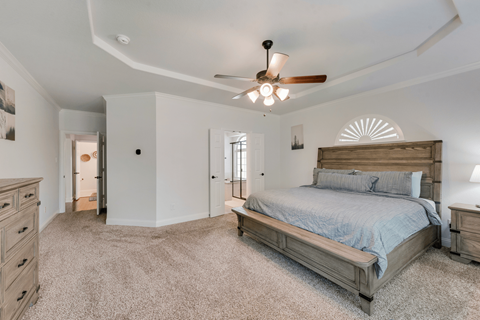 a bedroom with a bed and a ceiling fan