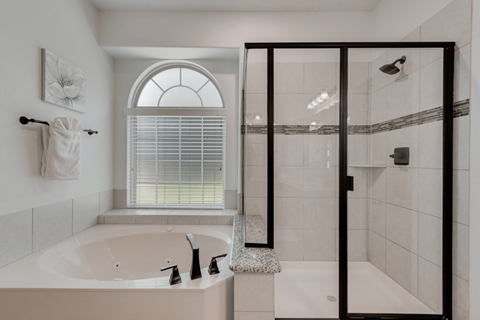 a bathroom with a tub and a shower and a window