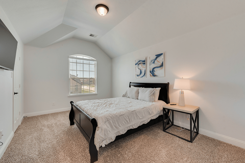 a bedroom with a large bed and a window