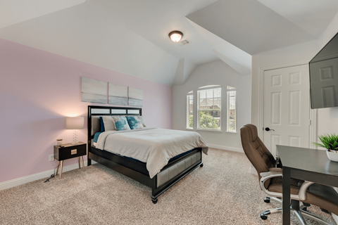 a bedroom with a bed and a desk with a chair